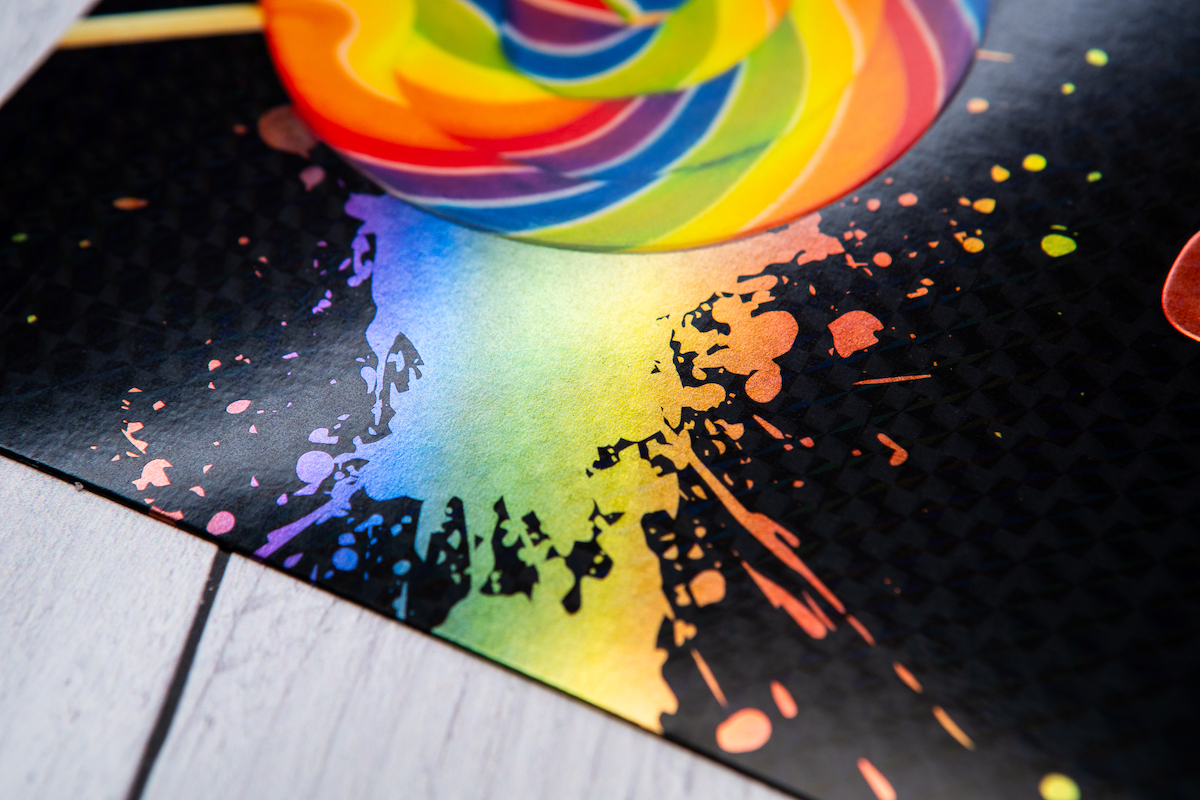 Up close of rainbow cold foil on black envelope